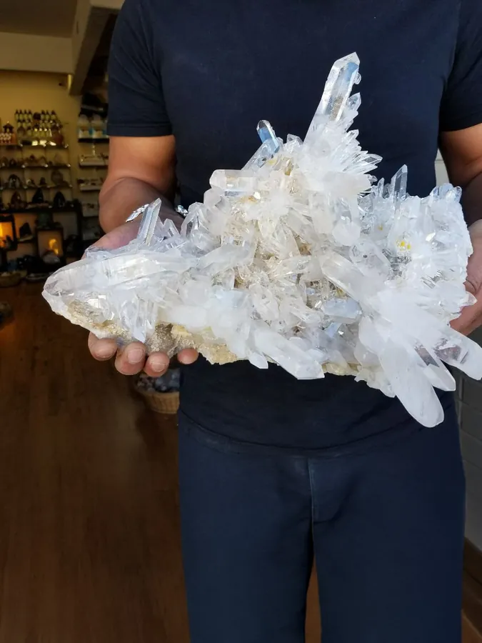 Large hand-sourced clear quartz crystal cluster held inside Stone Room